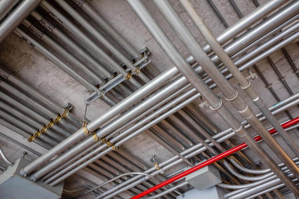 Overhead EMT conduit runs in a service area. 