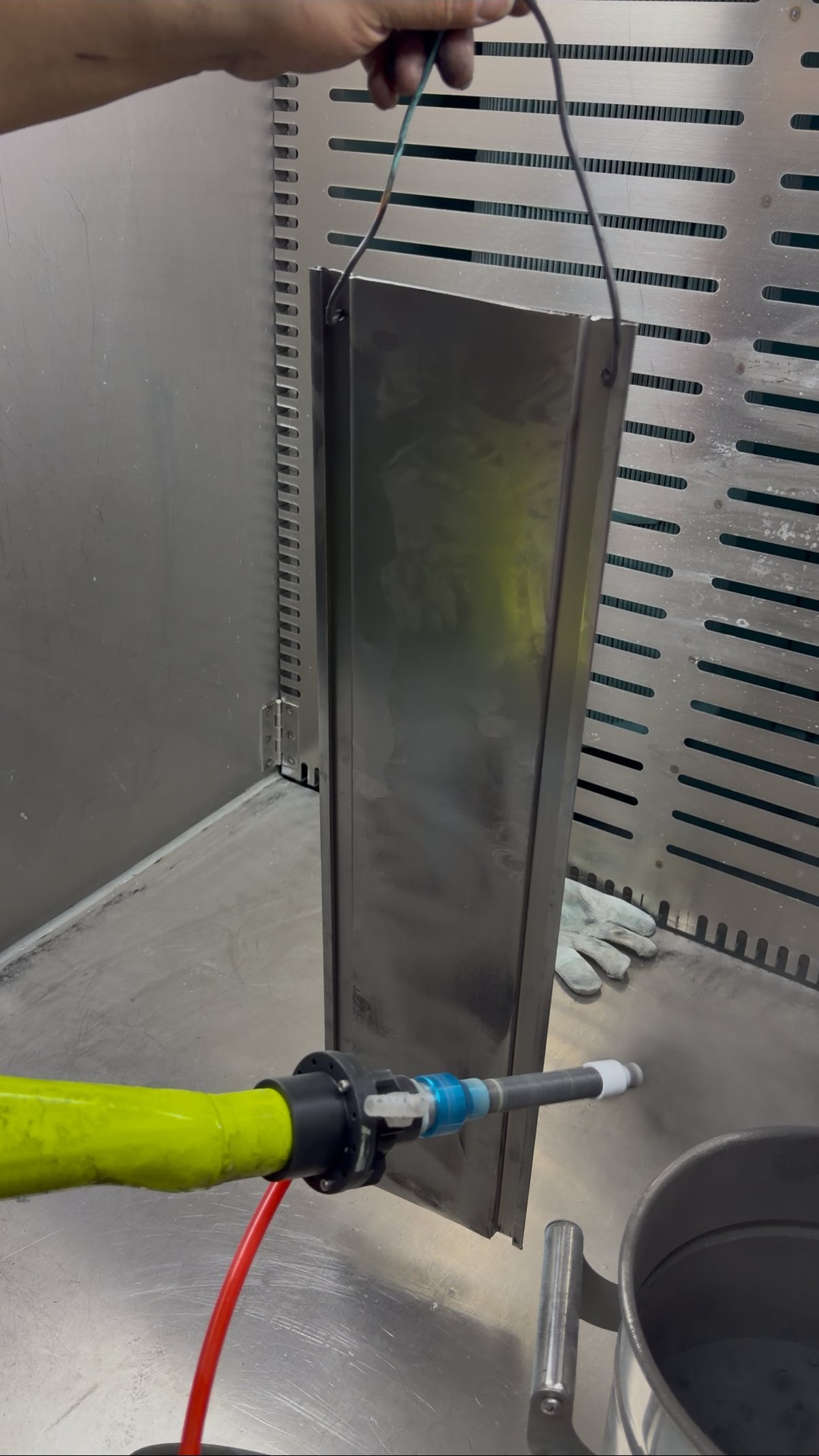 Q7 handheld powder coating gun spraying flat steel panel in production booth